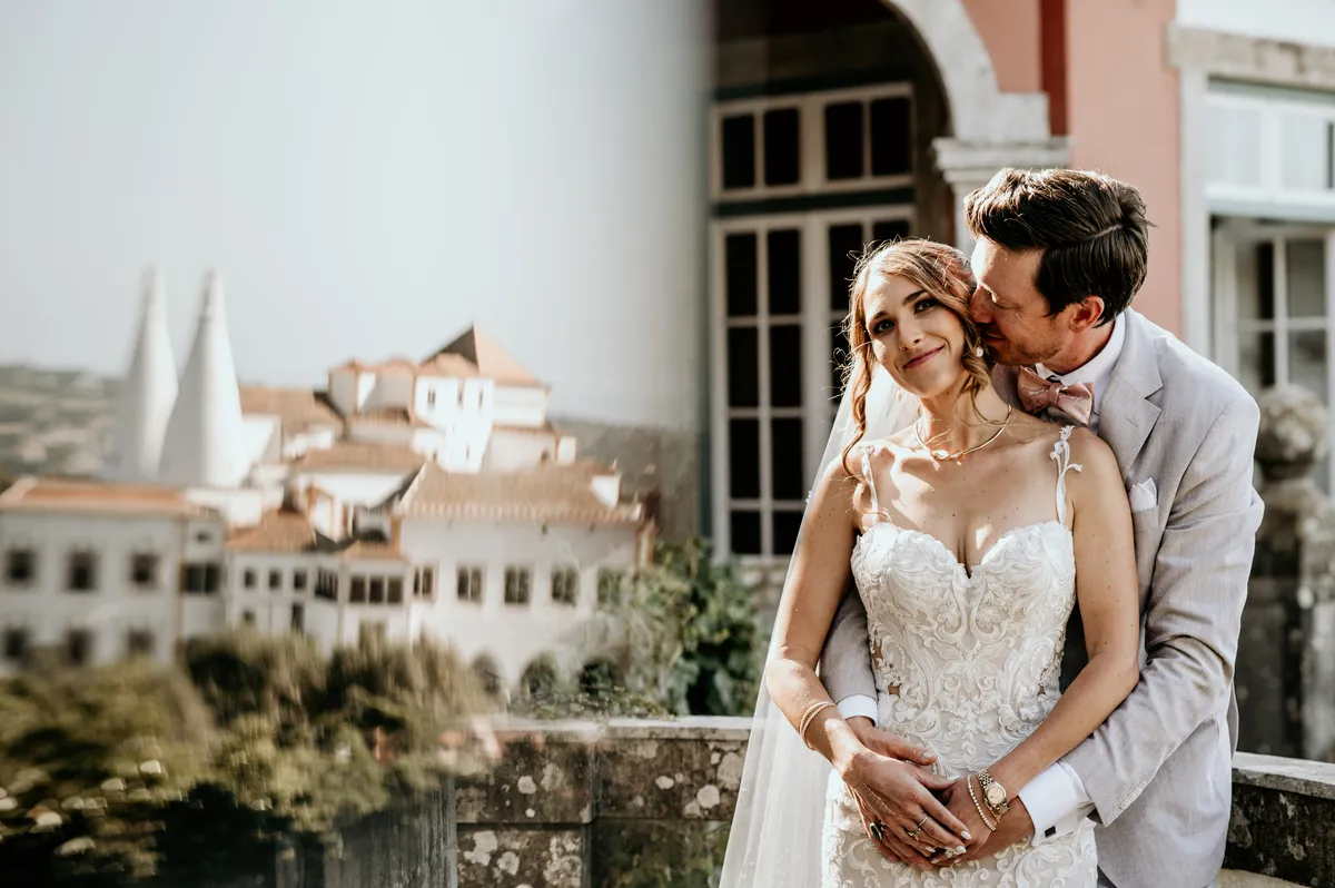 Cassidy e Brett abraçados com o Palácio de Sintra ao fundo