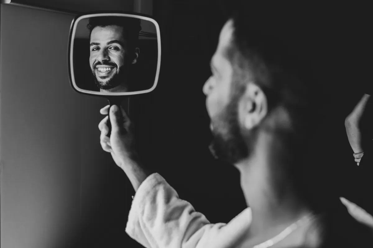 Um rosto refletido num espelho de mão