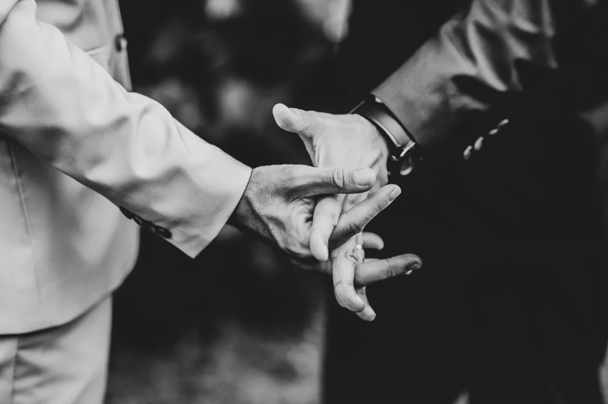 Duas mãos entrelaçadas, a preto e branco