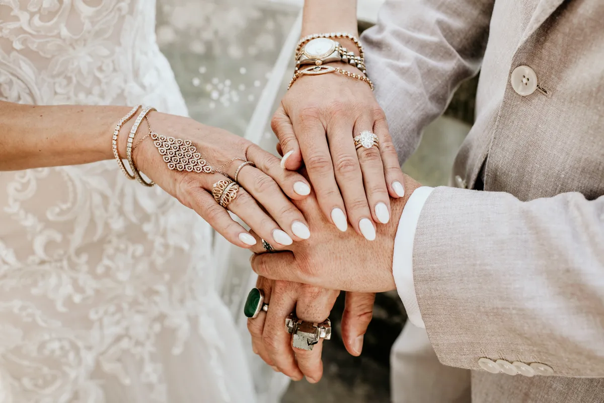 Mãos com alianças e pulseiras